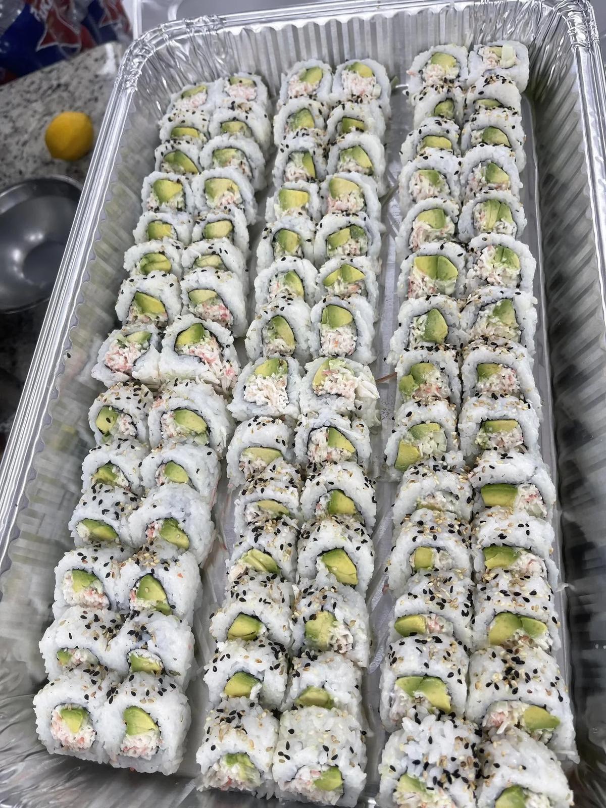A large catering tray of sushi rolls